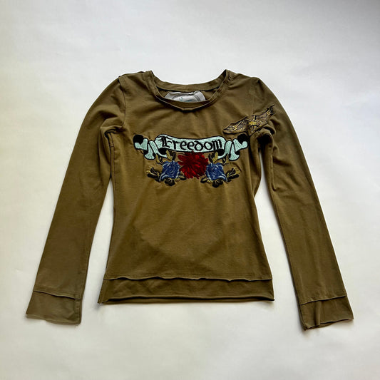 This is a long sleeve top with multicolored embroidery graphic design. The design says 'freedom' on it.  Crewneck with raw edges.